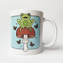 Laden Sie das Bild in den Galerie-Viewer, Cheerful Frog with Brown Mushrooms and Butterflies | Mushroom Pals | Ceramic Mug - Scaredy Cat Studio
