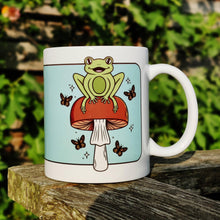 Laden Sie das Bild in den Galerie-Viewer, Cheerful Frog with Brown Mushrooms and Butterflies | Mushroom Pals | Ceramic Mug - Scaredy Cat Studio
